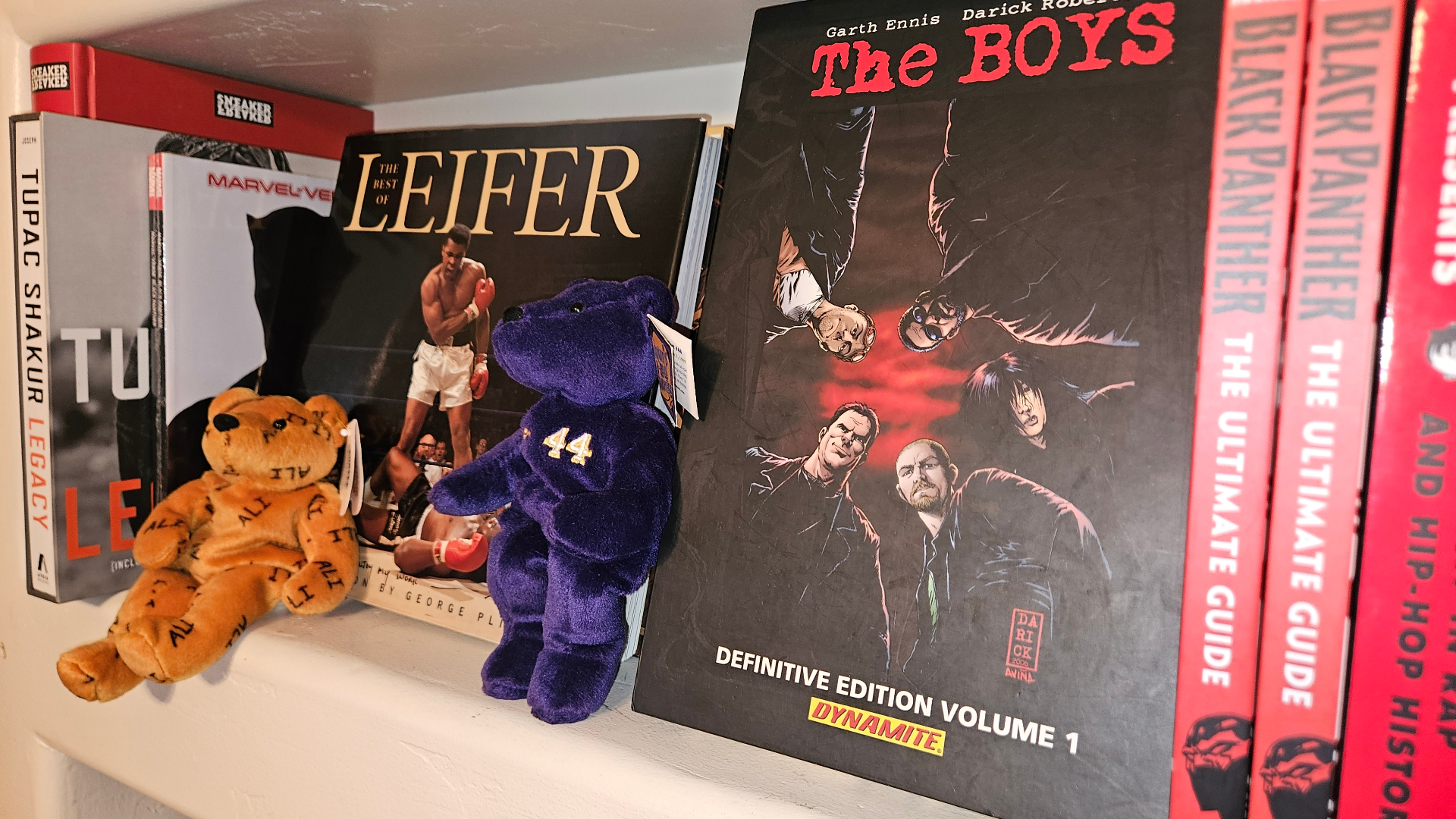 Bookshelf vignette with Muhammad Ali and comics.
